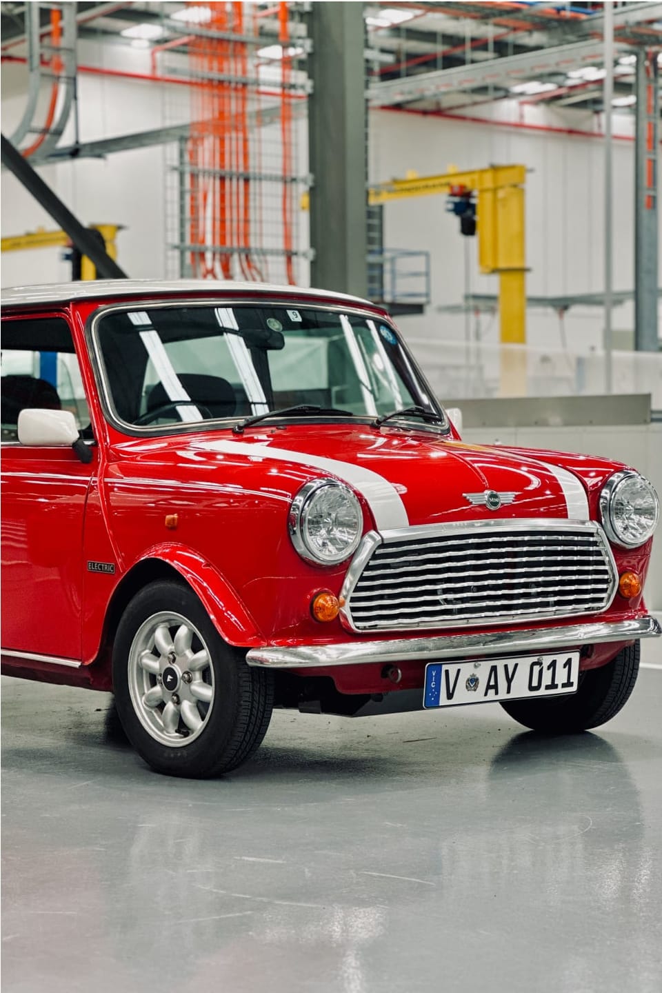 Red Classic Mini in the Jaunt workshop, front three-quarter, before conversion.
