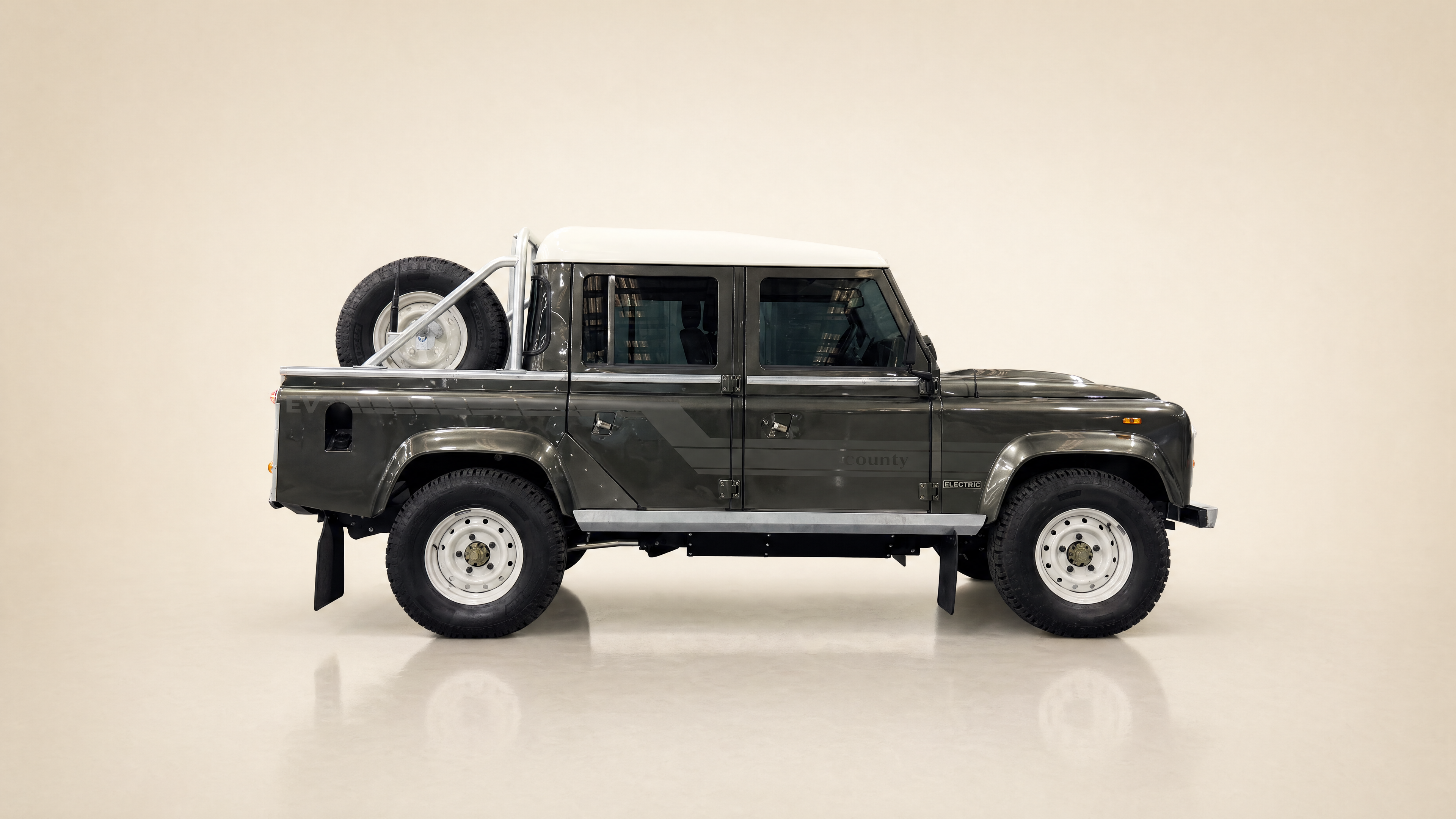 Land Rover Defender 110 dual-cab pickup, dark grey with white roof, side profile